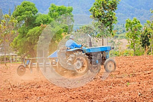 Blue tractor work on the field.