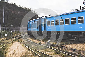Blue train along mountains