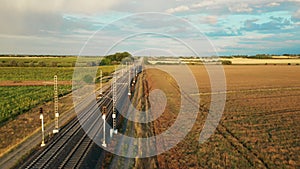 Blue train moves steadily through vast expanse of meadow