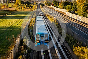 Blue train passing through the countryside of Scarborough, Ontario, Canada