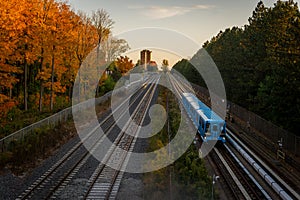 Blue train passing through the countryside of Scarborough, Ontario, Canada