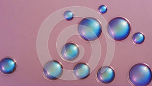 Blue translucent bubbles on pale pink background. Chaotic arrangement of balls. Soft volumetric lighting, blurred shadows