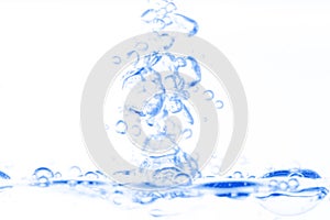 Blue transparent aqua water splash with bubbles on white clean background abstract