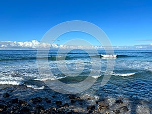 Blue transparent waves and blue sky, sunny autumn day on the coast of Playa de Las Americas, Tenerife, Canary Islands, Spain