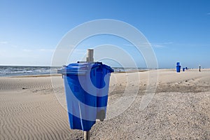 Blue trash cans dustbin on an empty beach