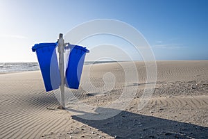 Blue trash cans dustbin on an empty beach