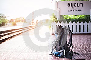 Blue Travel backpack put recline wooden bench in Ayutthaya train station