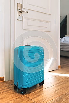 Blue travel suitcase in hotel apartment