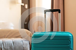 Blue travel suitcase in hotel apartment