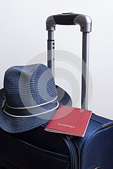 blue travel suitcase with passport, hat on the white bacground