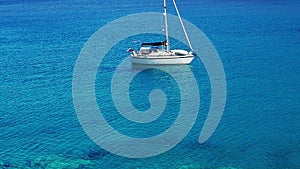 Blue and turquoise sea of the Aegean and white sailing boat, Greece