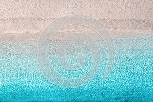 Blue, turquoise transparent water surface of ocean, sea, lagoon. Horizontal background. Top view of sand beach. Aerial, drone view