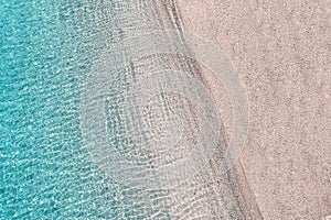 Blue, turquoise transparent water surface of ocean, sea, lagoon. Horizontal background. Top view of sand beach. Aerial, drone view