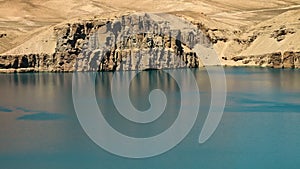 Blue turquoise water with sand dunes and travertine cliffs in lake basin. Lake banks on ridges.