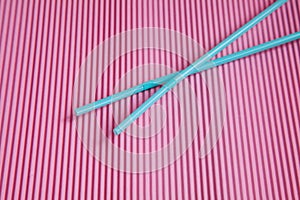Blue two drinking straws on a pink background, without a plastic Cup