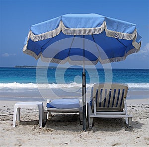 Blue umbrella and deckchairs