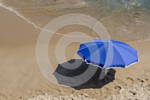 Blue umbrella on sand of the beach