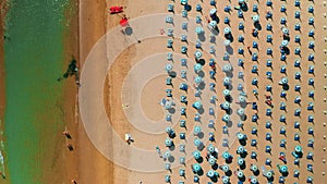 Blue umbrellas and sun lounges installed on sandy beach