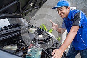 Blue uniform car engineer worker looking into car`s engine