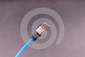 Blue USB cable on gray background side view