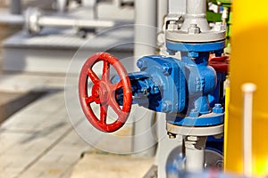 Blue valve on a yellow pipe at a gas processing plant