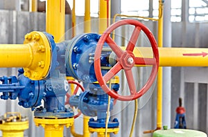 Blue valve on a yellow pipe at a gas processing plant