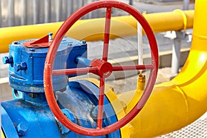 Blue valve on a yellow pipe at a gas processing plant