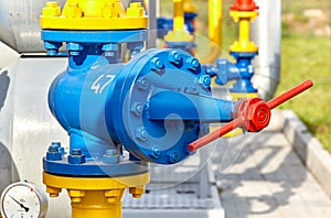 Blue valve on a yellow pipe at a gas processing plant