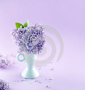 Blue vase with a bouquet of lilacs