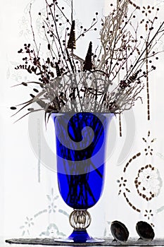 Blue vase with dried flowers and ornaments