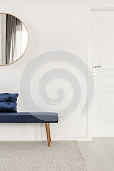 Blue velvet bench with pillow in white and bright corridor