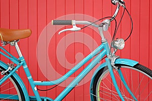 Blue vintage bicycle on red wooden wall background