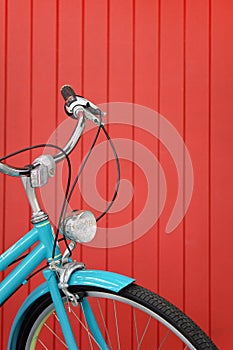 Blue vintage bicycle on red wooden wall background