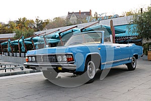 blue vintage car cabriolet by the restaurant