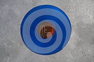 Blue Vinyl record on a stone background. Retro style. Top view.