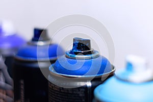 Blue and violet spray cans on graffiti on an isolated white background close-up