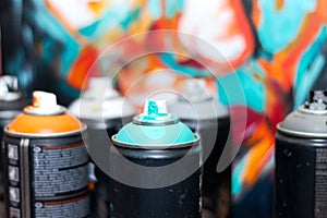 Blue and violet spray cans on graffiti on an isolated white background close-up.