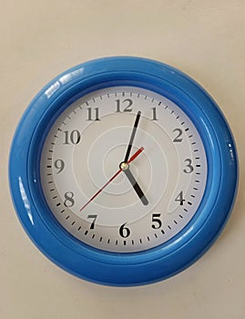 Blue wall clock on white background