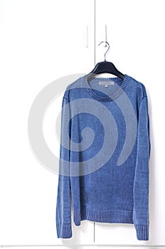 Blue Warm Sweater Hang on White Closet Door
