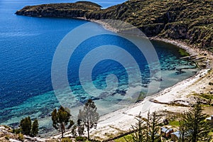 Blue water, coast of Titicaca lake and white sand beach at Incas