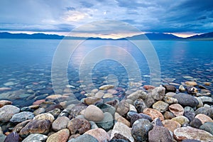 The blue water and cobblestone sunrise of Sailimu lake Xinjiang, China