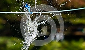 Blue, water-filled balloon on a line. Bursting