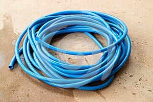 The blue water hose lay down on the floor
