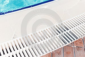 Blue water with light reflection at the edge of the curved swimming pool