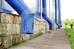 Blue water pipes on a large sports complex in summer. concept of protection against heavy downpours