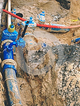 Blue water pipes and shut-off valve on pipe with branch