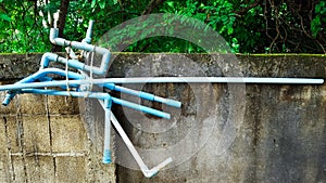 Blue water pipes tiding on the concrete fences