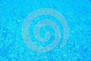 Blue water ripples in swimming pool with blue mosaic background