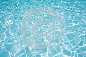 Blue water surface in swimming pool witn sun reflection