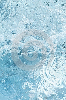 blue water surface with waves and bubbles